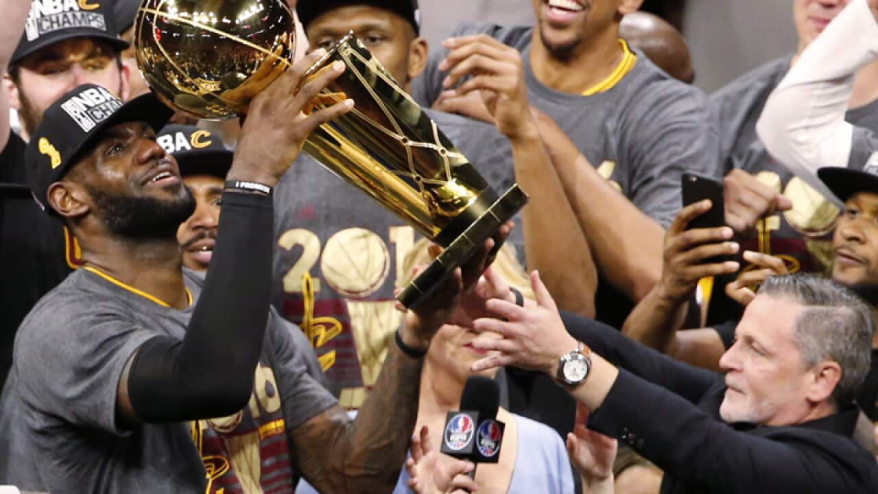 LeBron James of the Cleveland Cavaliers holds the Larry O'Brien Trophy