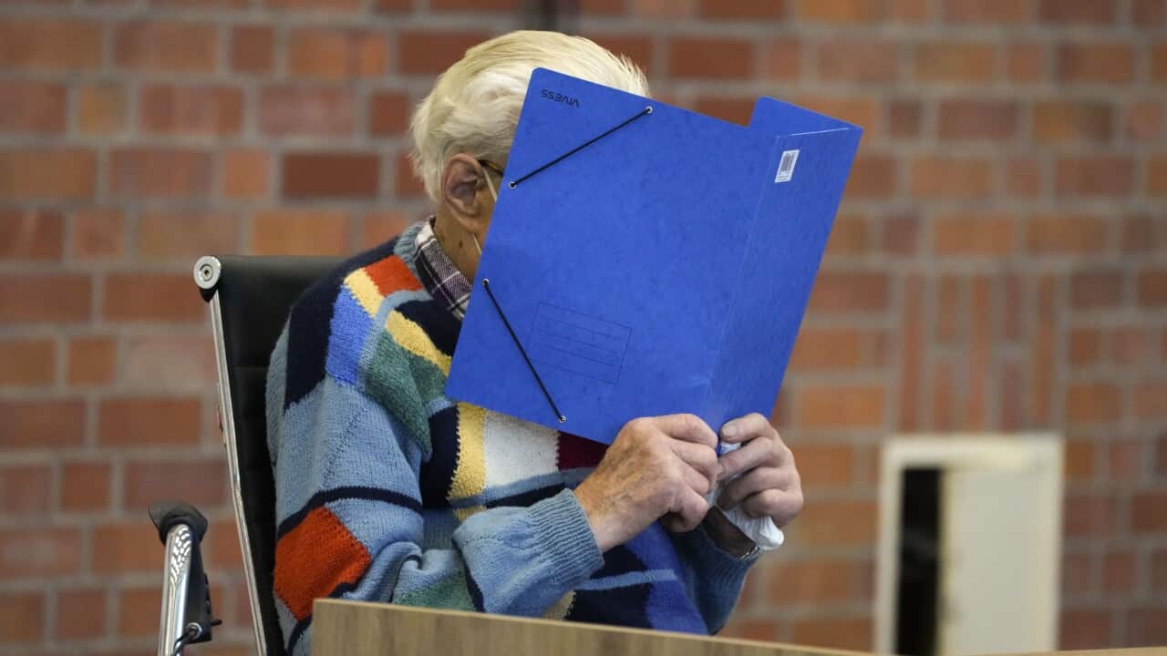 The accused Josef S. covers his face as he sits at the court room in Brandenburg, Germany.