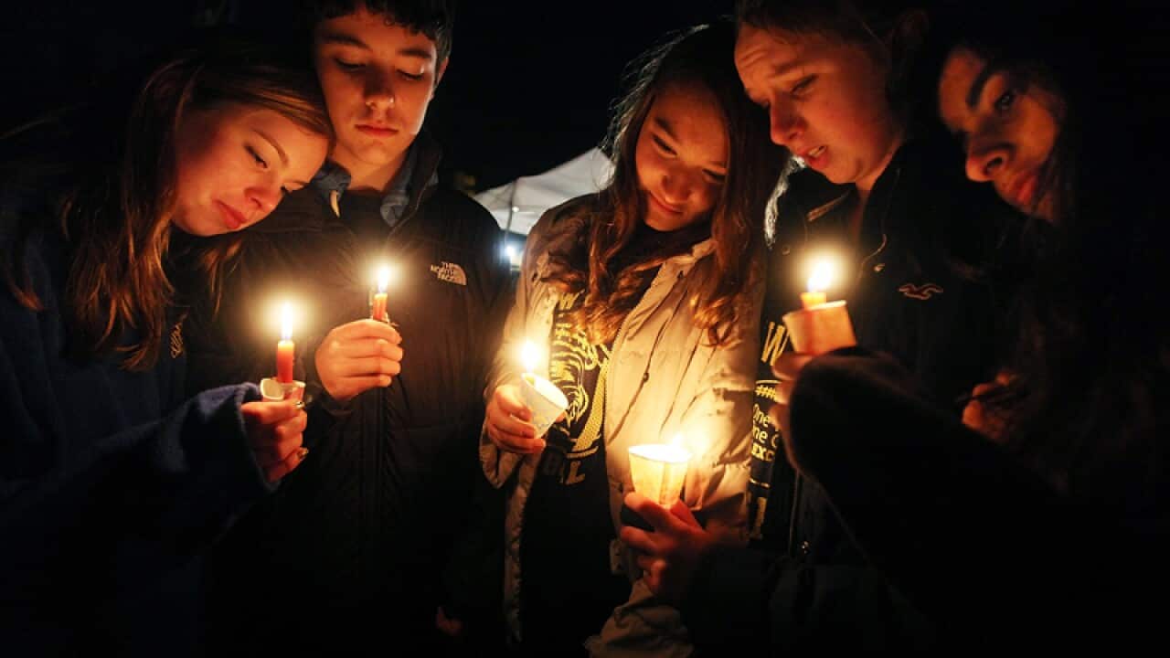 Newtown residents hold candles at a memorial for victims on the first Sunday following the mass shooting at Sandy Hook Elementary School, Connecticut. (Getty)