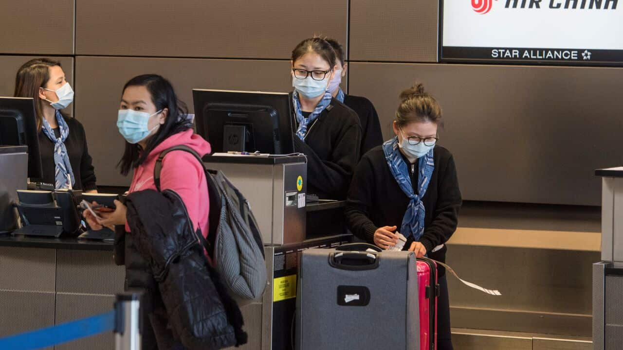 Chinese citizens wear face masks as they check in to their Air China flight to Beijing, at Los Angeles International Airport.
