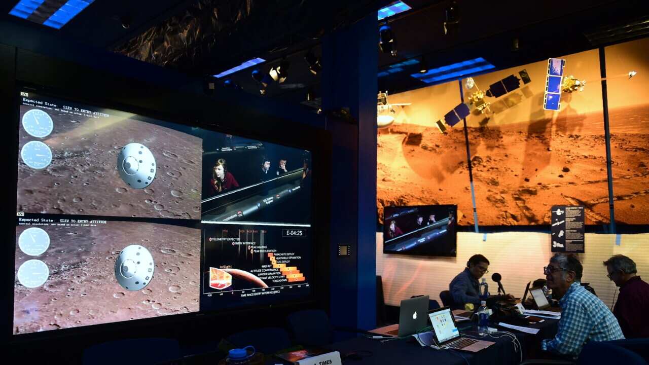 People watch the landing of NASA's InSight spacecraft on the planet Mars on television screens at NASA's Jet Propulsion Laboratory (JPL) in Pasadena, California on November 26, 2018.
