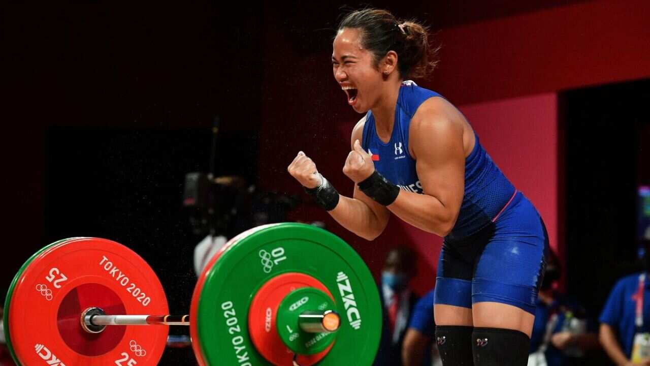 Philippines' Hidilyn Diaz reacts while competing in the women's 55kg weightlifting competition during the Tokyo 2020 Olympic Games