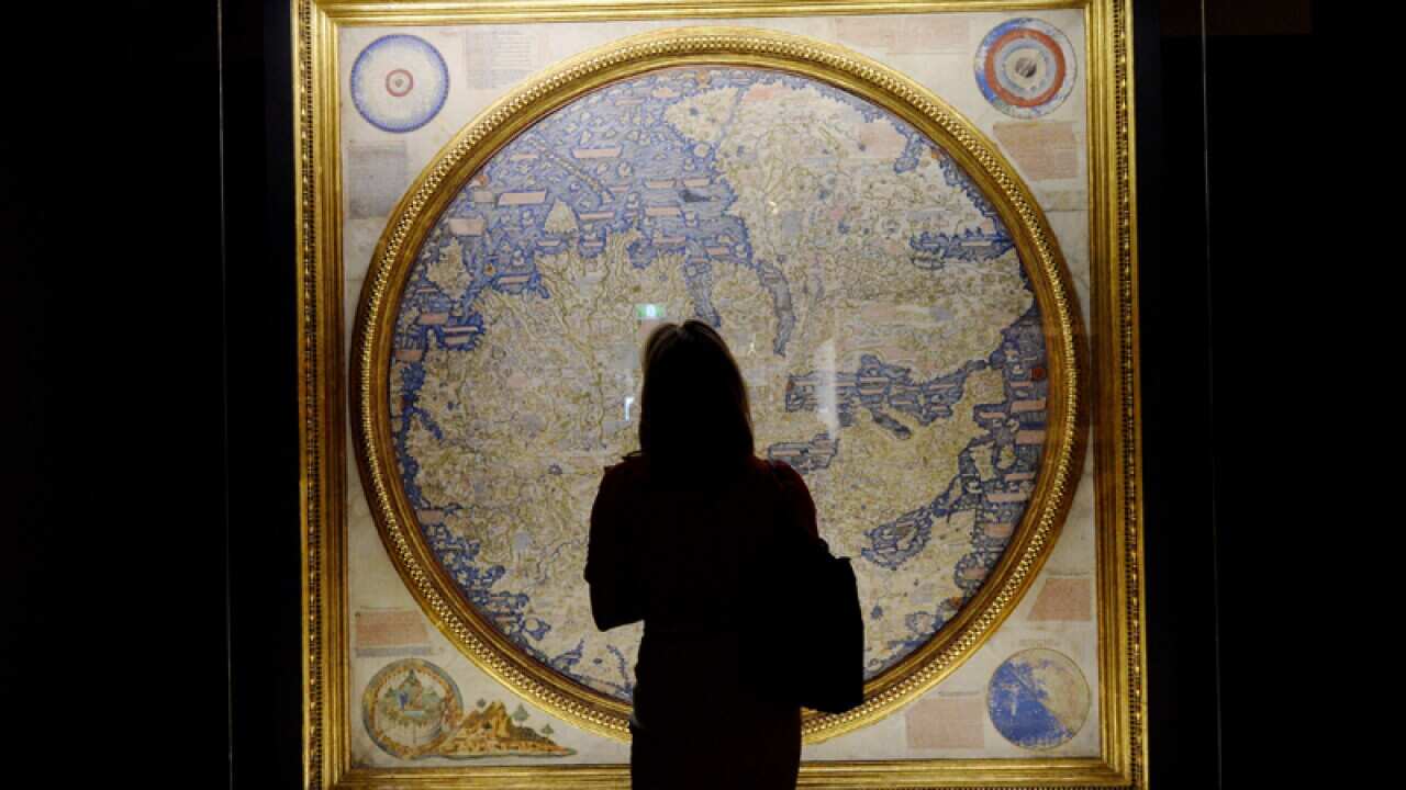 A woman looks at the Fra Mauro map