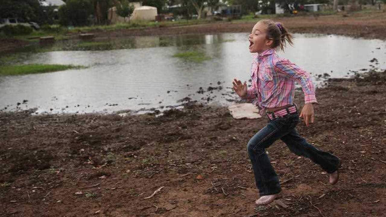 Felicity Mammen, 7, runs past a dam that was empty weeks ago on her family's farm in north west NSW in February.