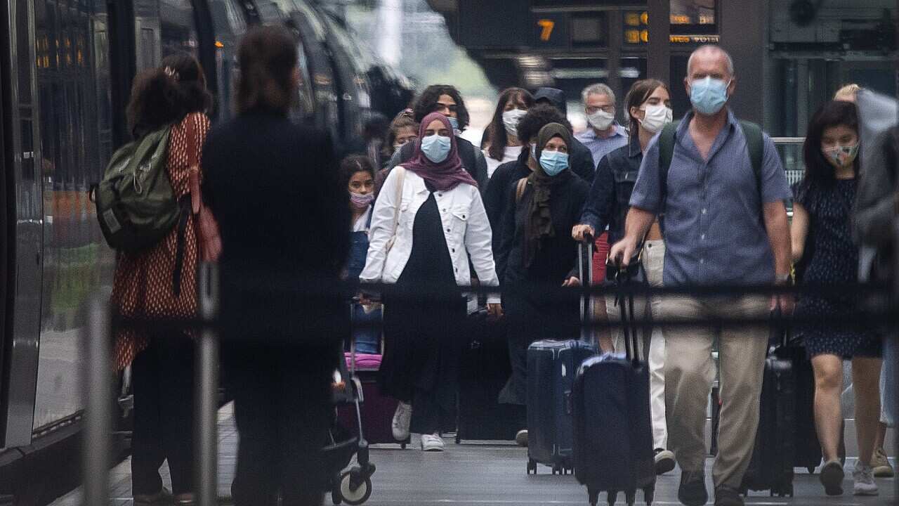 Travellers wearing face masks arrive in London from Paris after quarantine restrictions were imposed on Saturday morning.