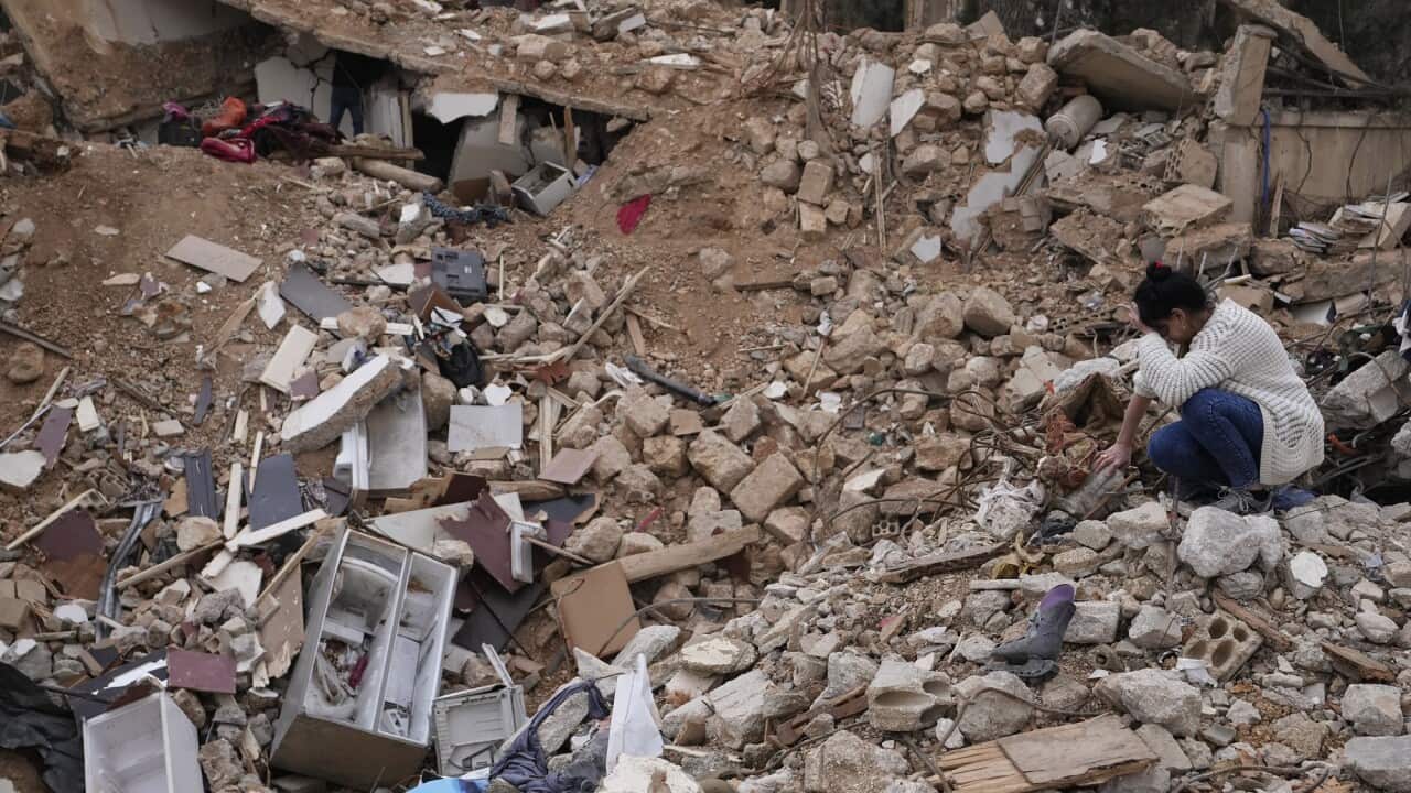 Lina Rida Jawhari cries as she sits on the rubble of her family's destroyed house in Lebanon.