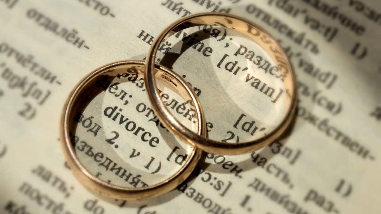 Two separate wedding rings next to the word "divorce". The concept of divorce, parting, infidelity . Selective focus.