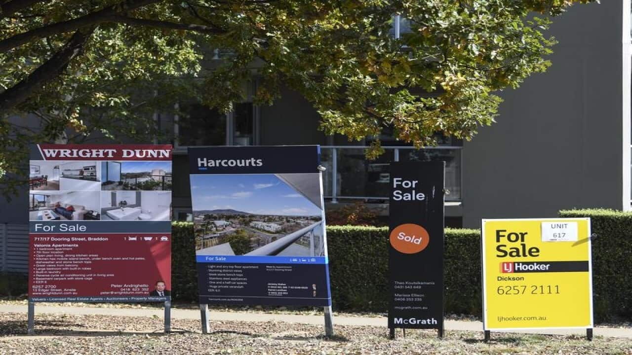 For sale signs in front of an apartment block