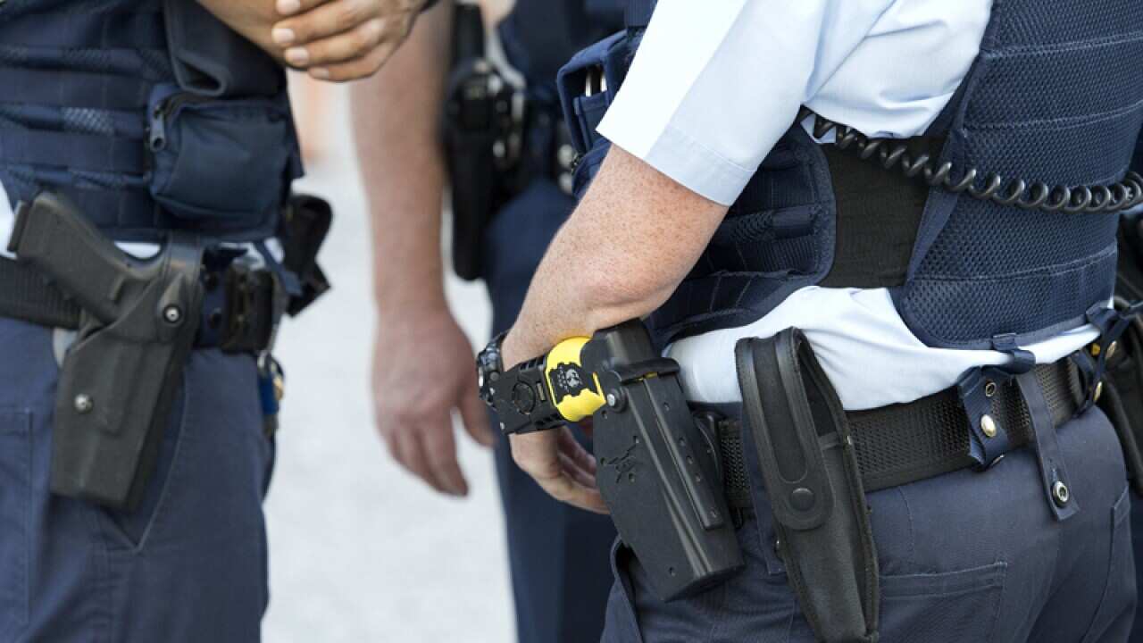 Police Officers wearing hand guns and tasers