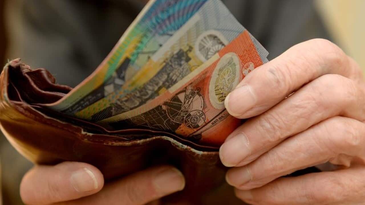Money is taken out of a wallet.