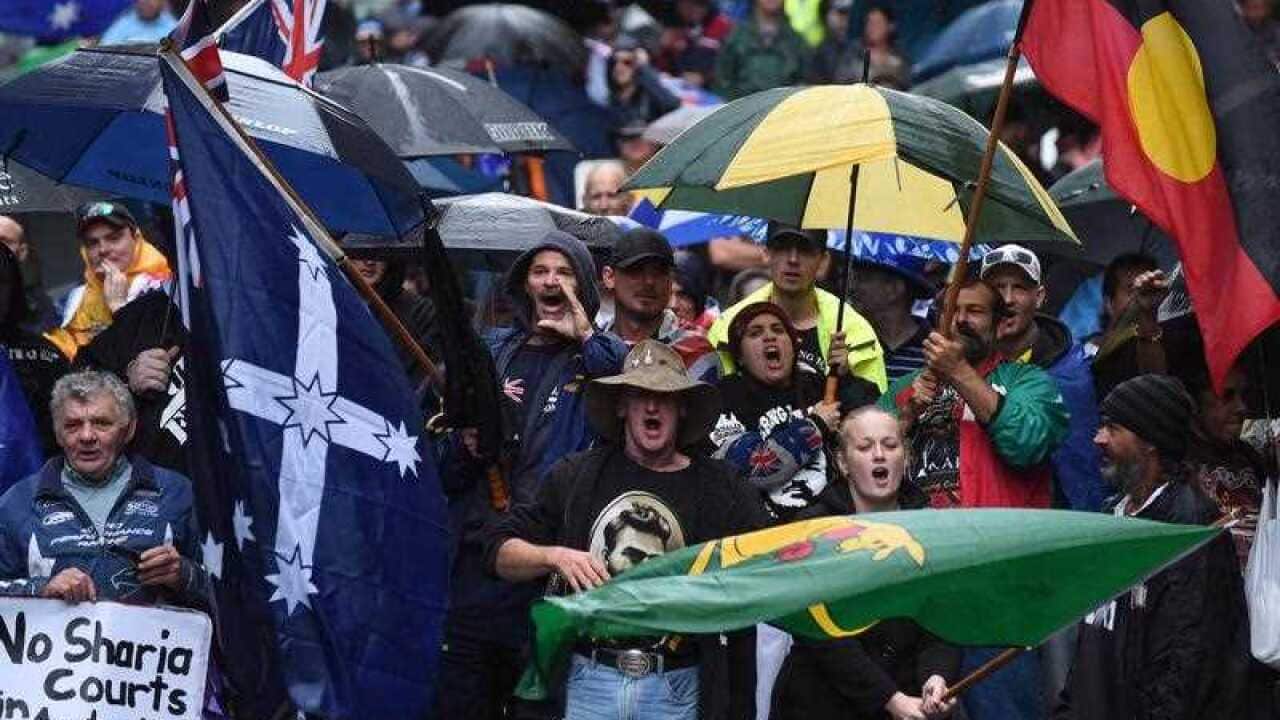 Protesters holding flags are seen at a Reclaim Australia Rally at Martin Place in Sydney on Saturday. (AAP)