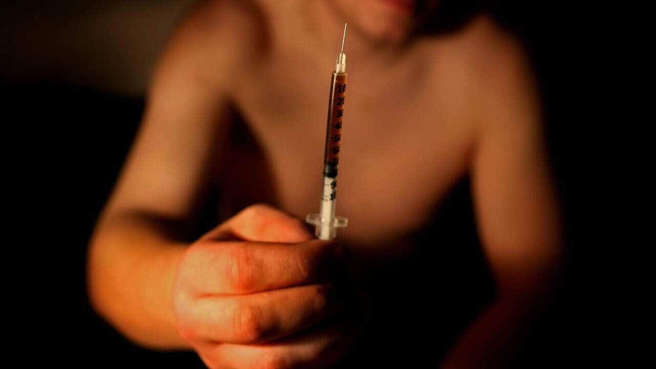 A heroin addict with a syringe of illicit heroin. (AAP)