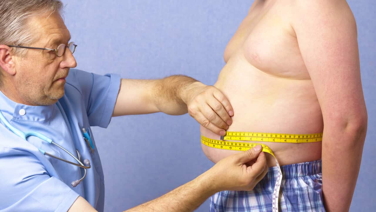 Senior doctor measuring 12 year old obese boy