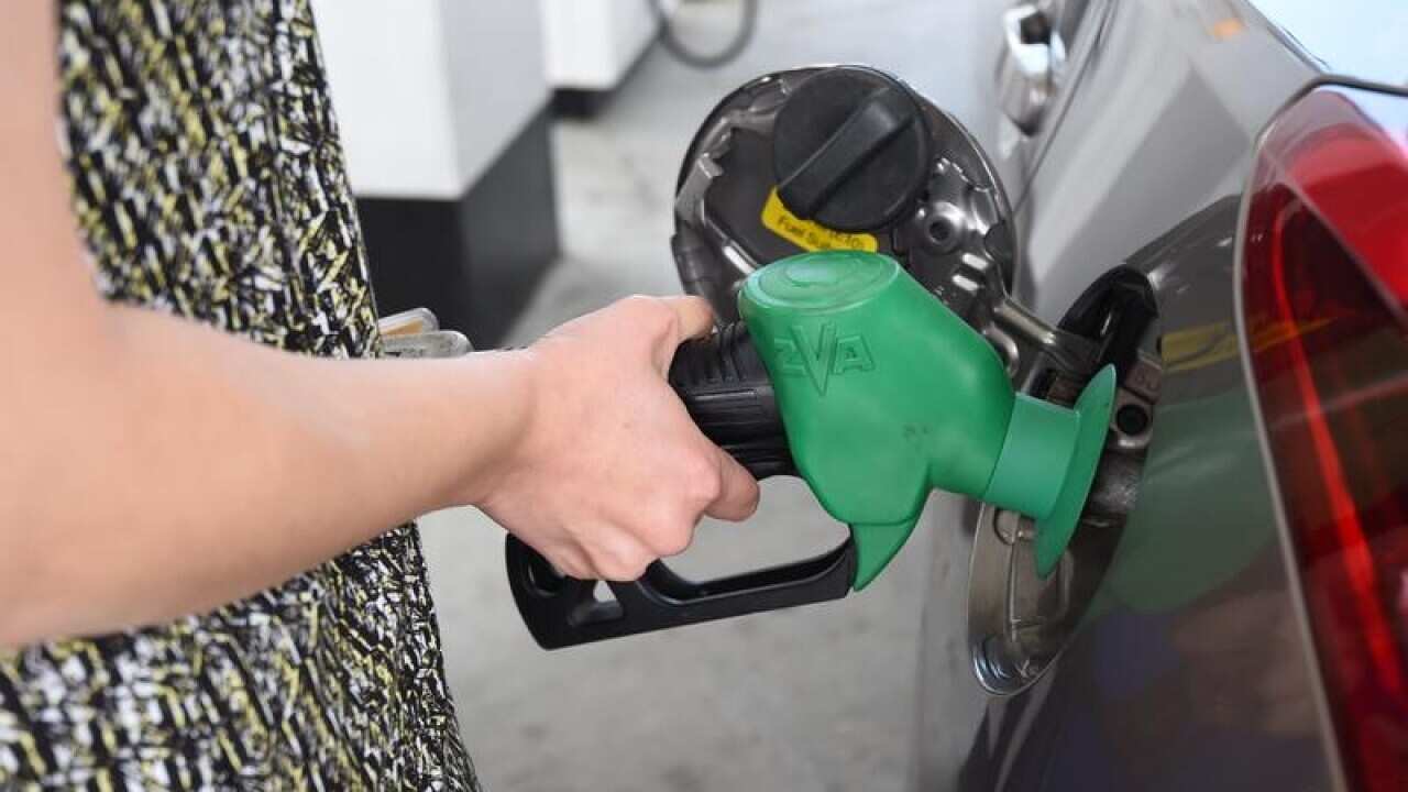 A motorist refuels her car at a service station