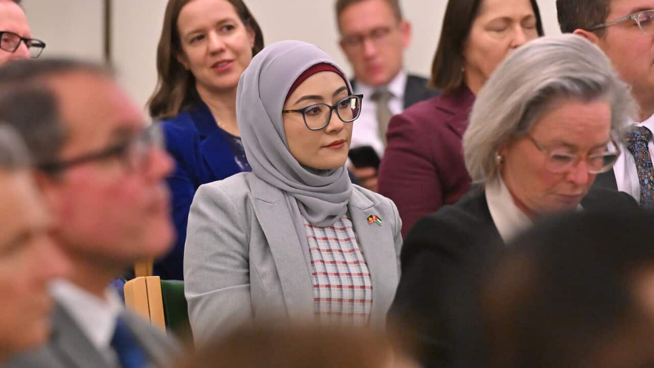 Fatima Payman seated among several other people.