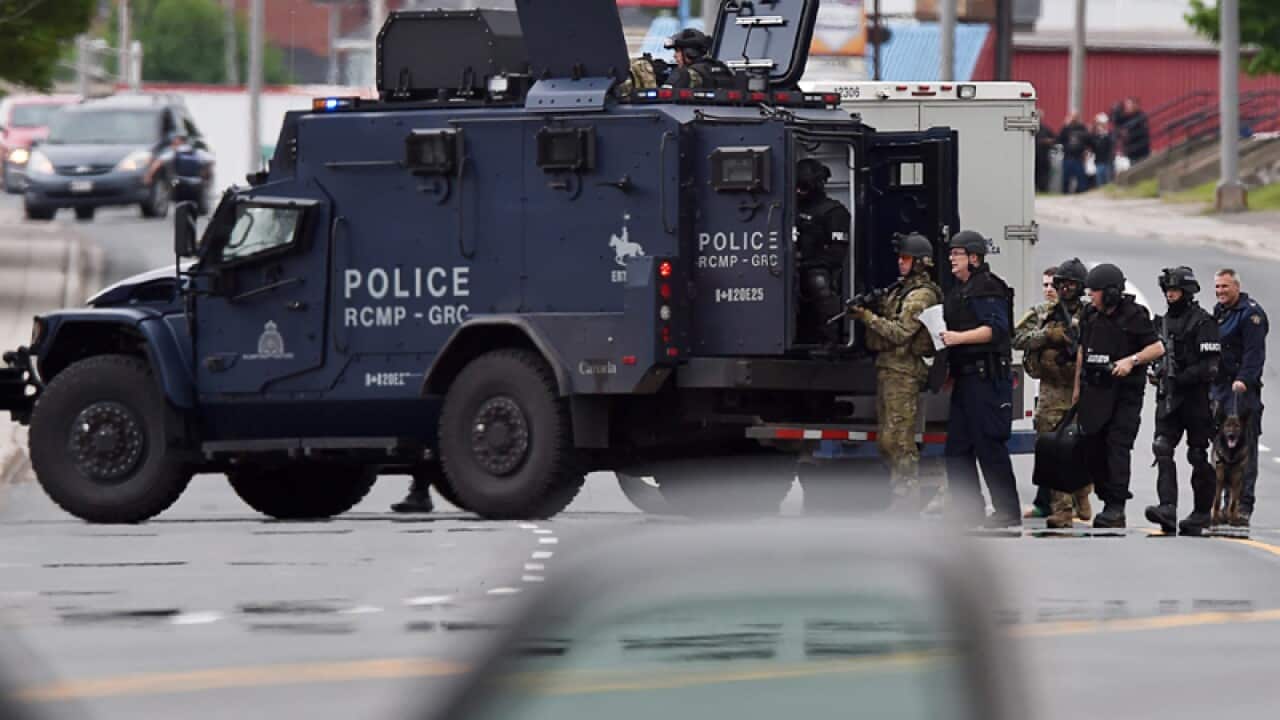 Emergency response officers wait outside a residence in Moncton
