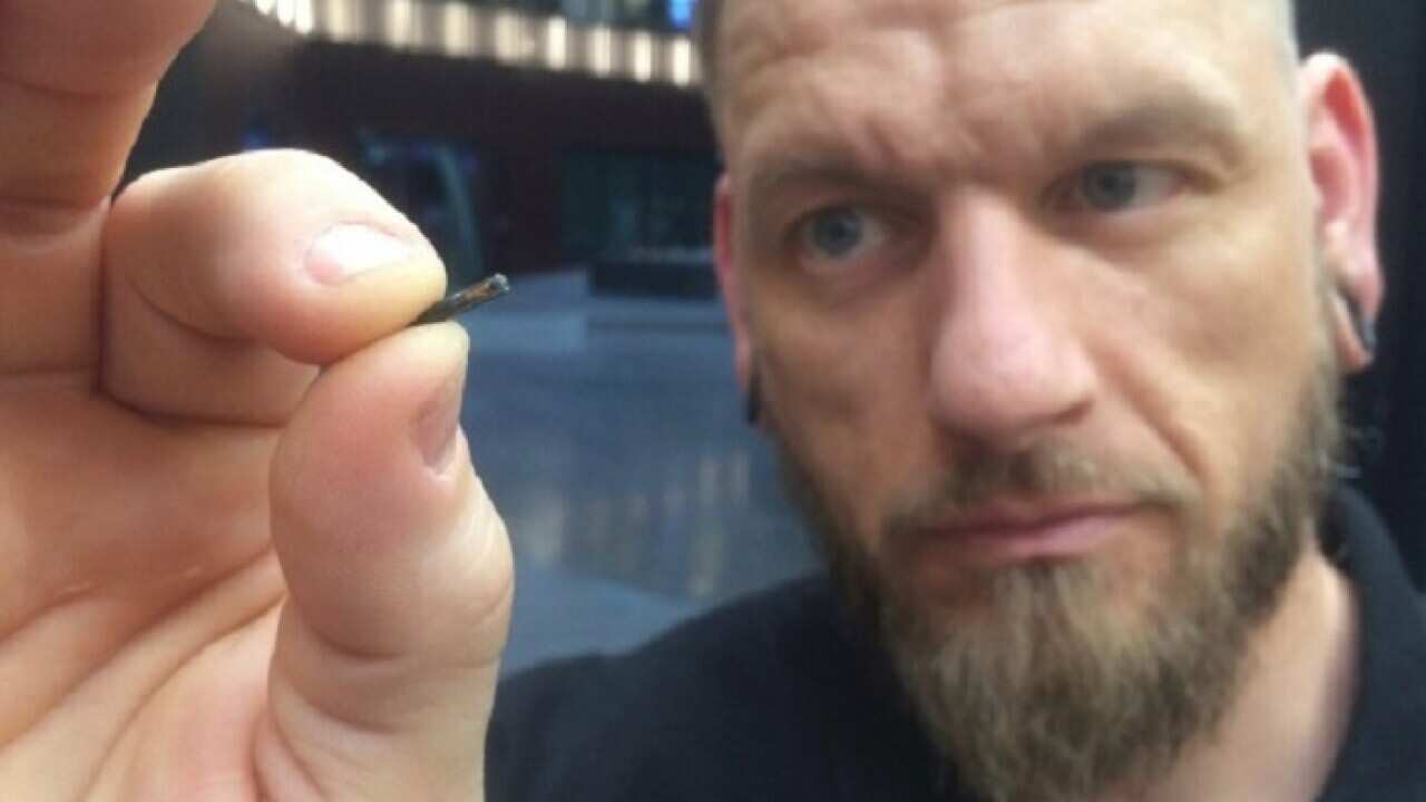 Self-described “body hacker” Jowan Osterlund, of Biohax Sweden, holds a microchip device similar to those implanted in workers at the Epicenter digital innovation business centre.