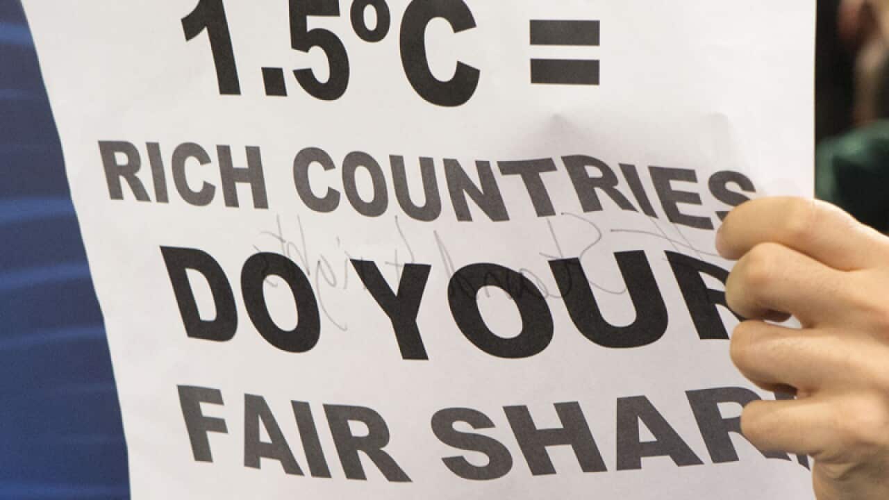 A protester holds a sign during a protest at the COP21 summit