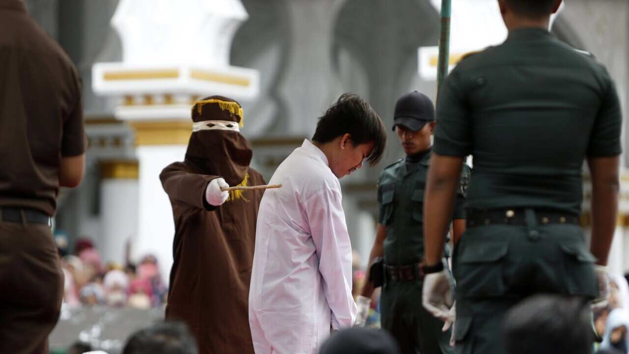 A man is whipped in front of the public as punishment for being in a same-sex relationship in Banda Aceh, Indonesia, 23 May 2017.