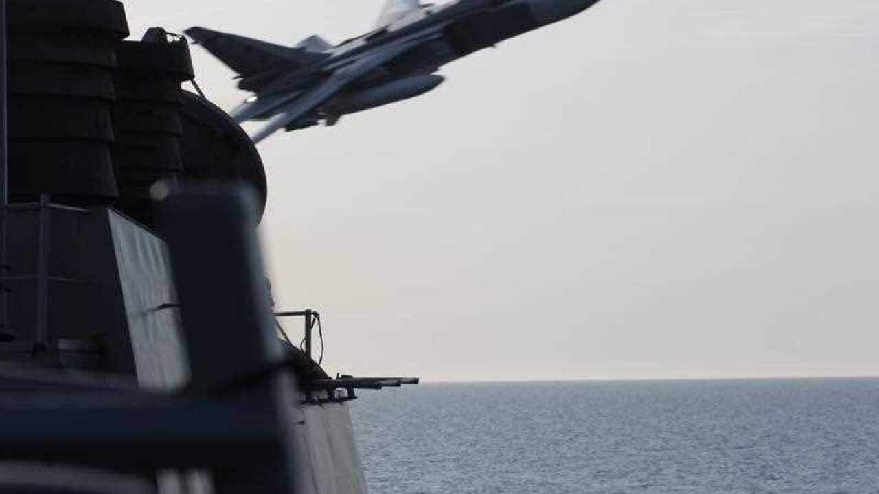 In this image released by the U.S. Navy, a Russian SU-24 jet makes a close-range and low altitude pass near the USS Donald Cook on Tuesday, April 12