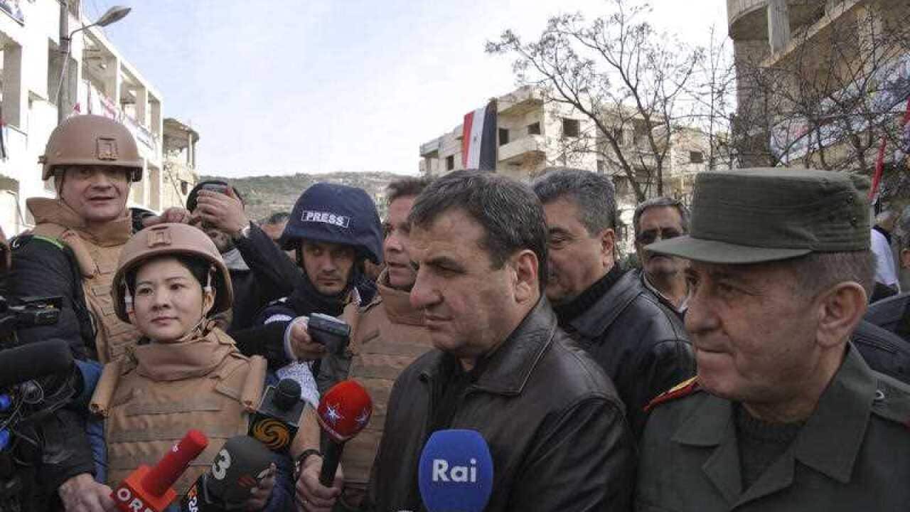 Ibrahim Khder al-Saalem, center, the governor of Latakia province, speaks to reporters in Salma, Syria
