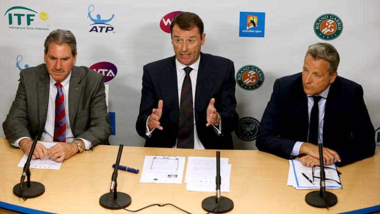 Wimbledon Chairman Philip Brook, center, speaks, along with ATP Executive Chairman and President Chris Kermode, right, and International Tennis Federation President David Haggerty