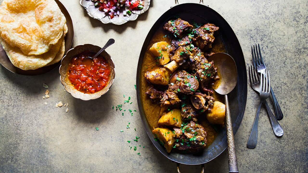 Bengali goat curry with fried puffed bread (kosha mangsho with luchi)