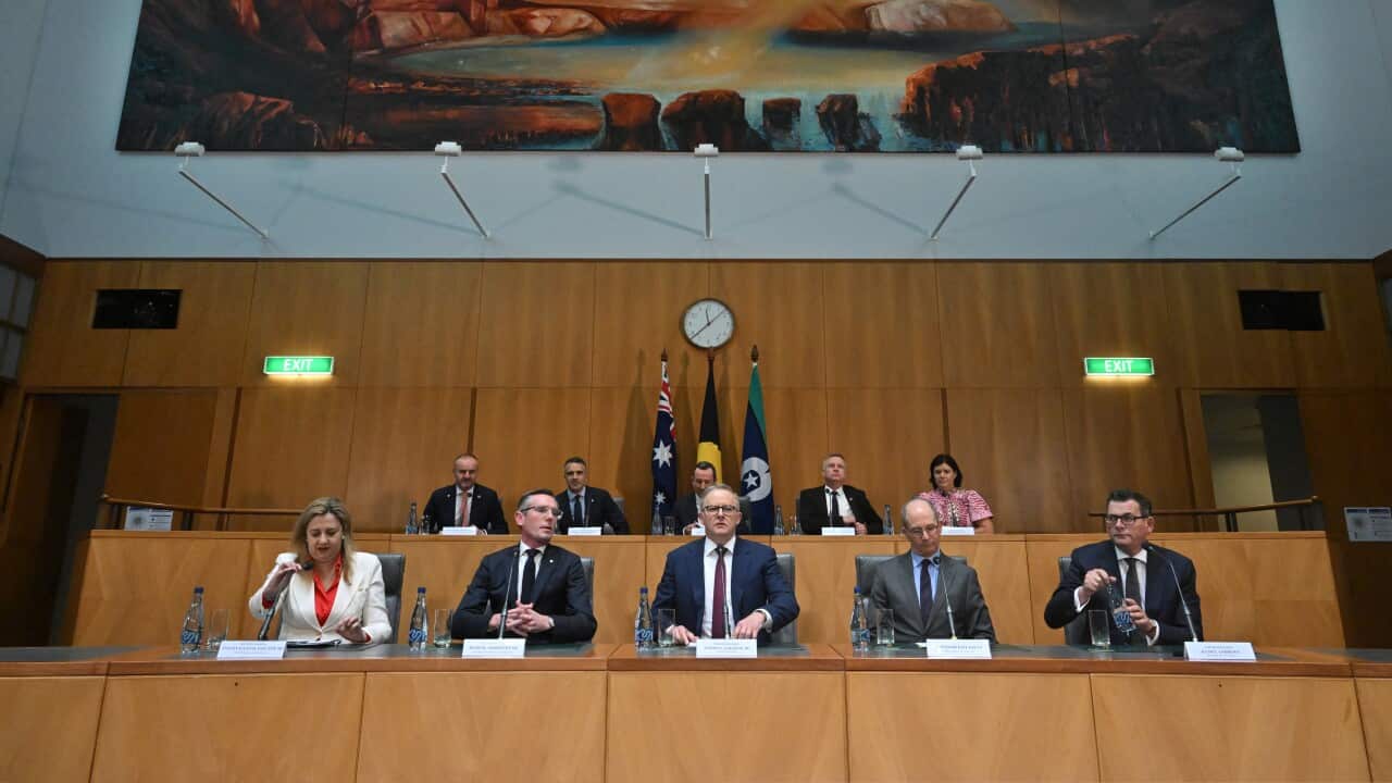 Men and women seated in a room at Parliament House.