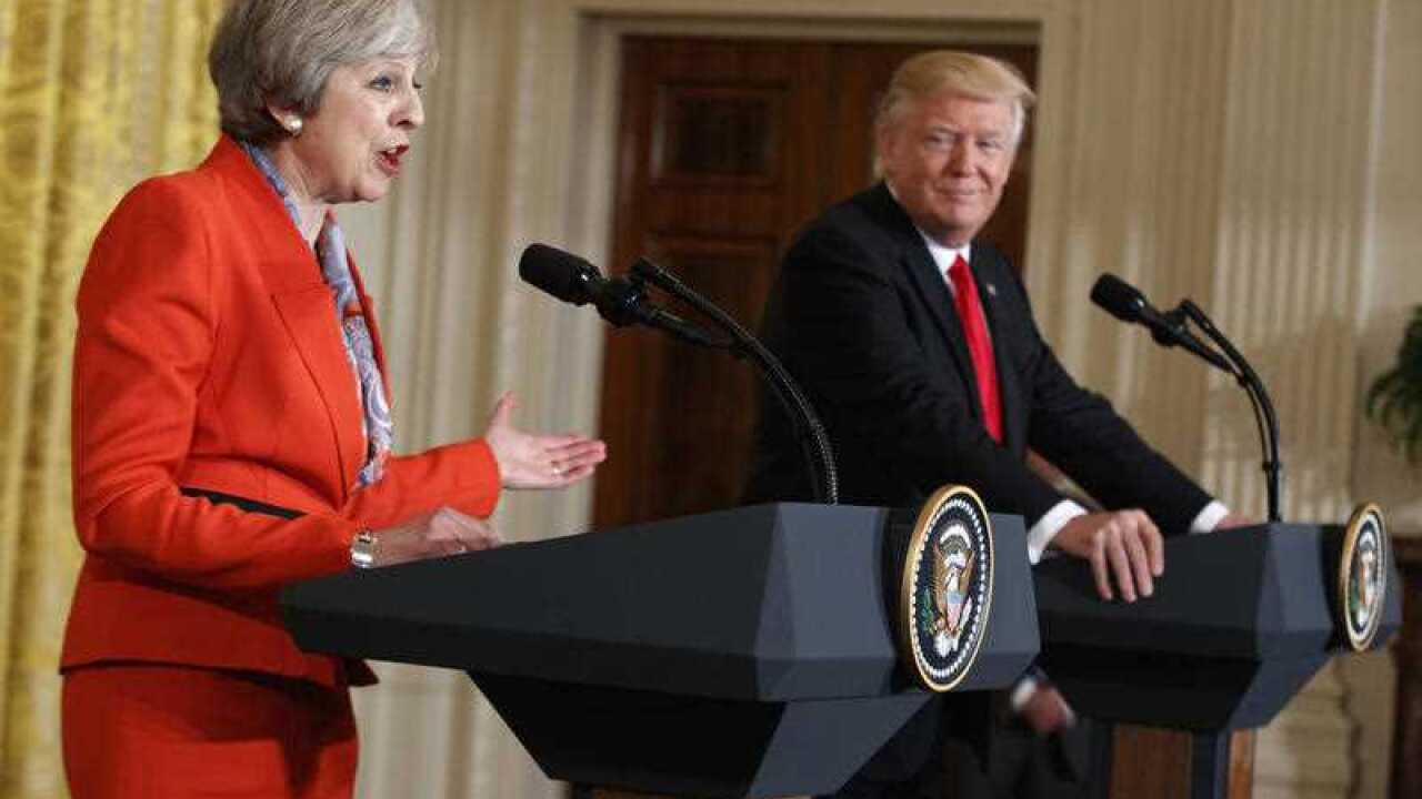 President Donald Trump listens as British Prime Minister Theresa May speaks during a news conference in the East Room of the White House