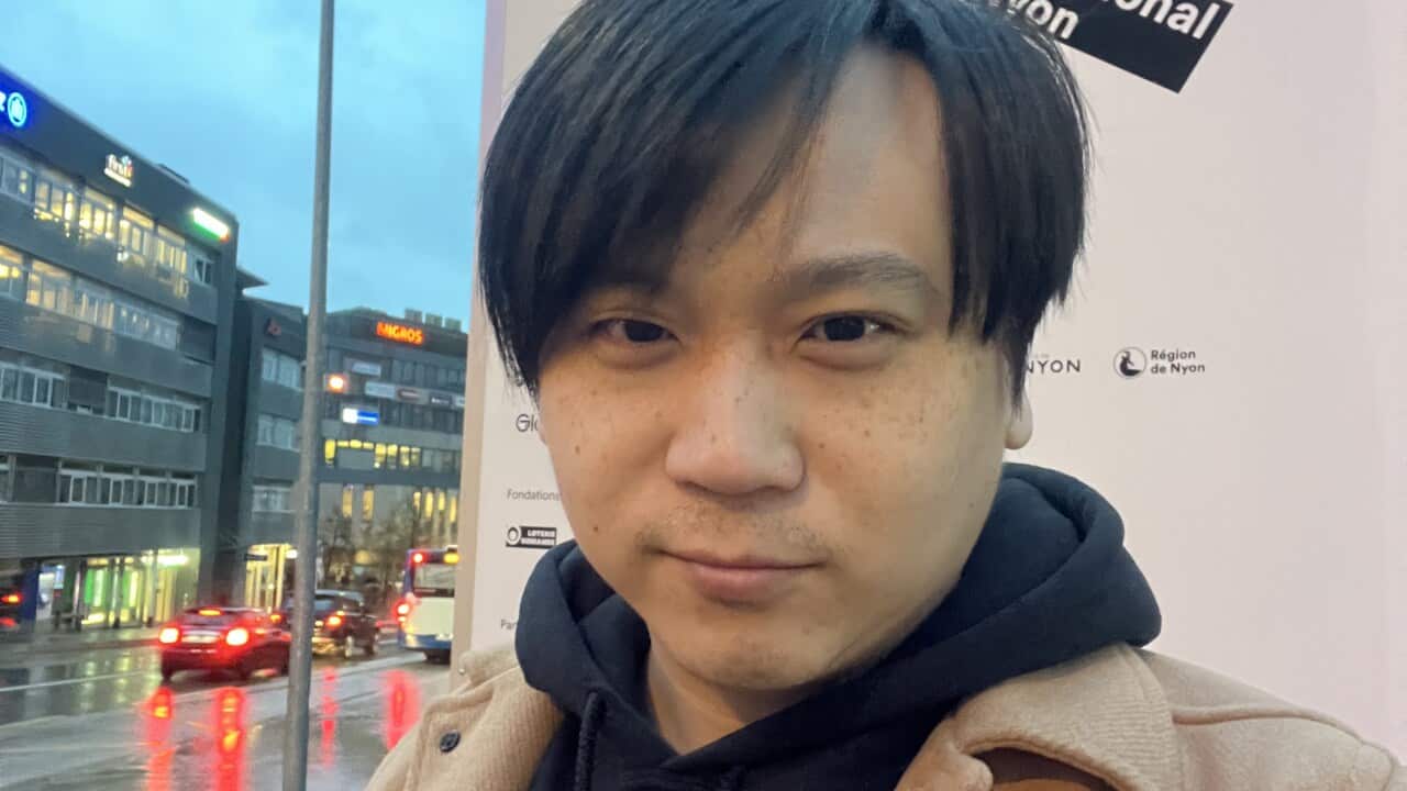 Man standing in front of a film festival poster.
