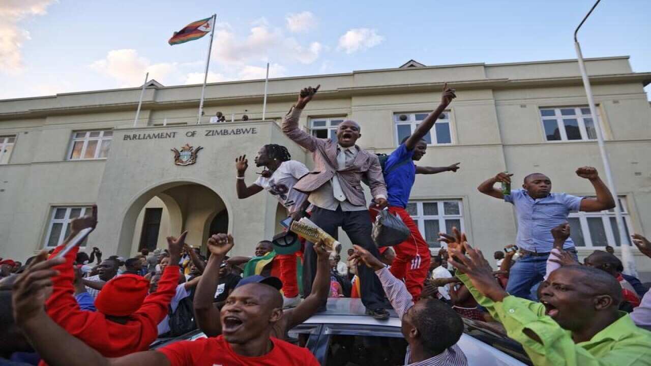 Zimbabweans celebrate outside the parliament building
