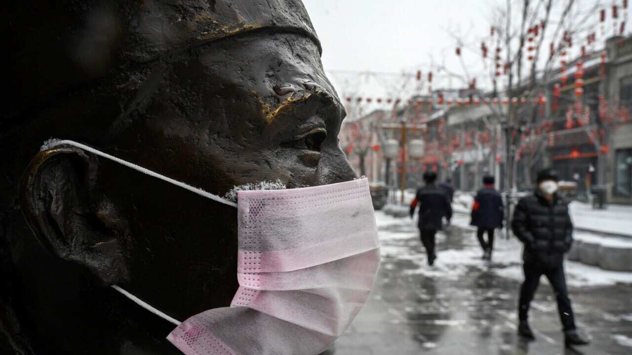 A protective mask on a statue outside a restaurant in Beijing