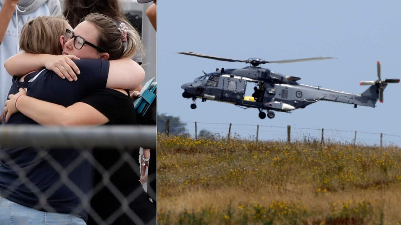 Families embrace while New Zealand rescue crews extract the remains of six people killed in the White Island volcanic eruption.