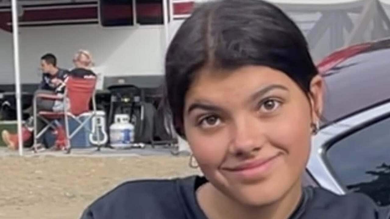 A young woman on a bike smiling at the camera