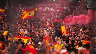 Crowd of people with many holding up Spanish flags.