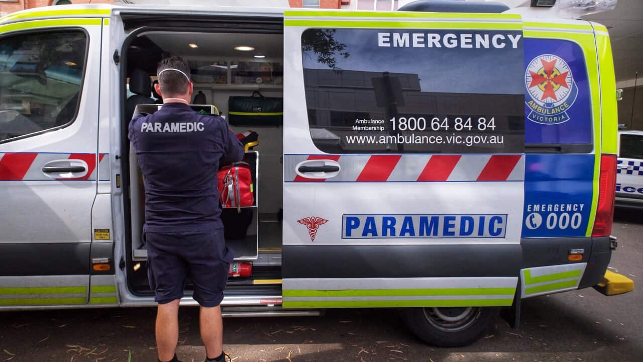 Paramedics are seen tending to their ambulance outside St. Vincent hospital in Melbourne, Tuesday, January 11, 2022.