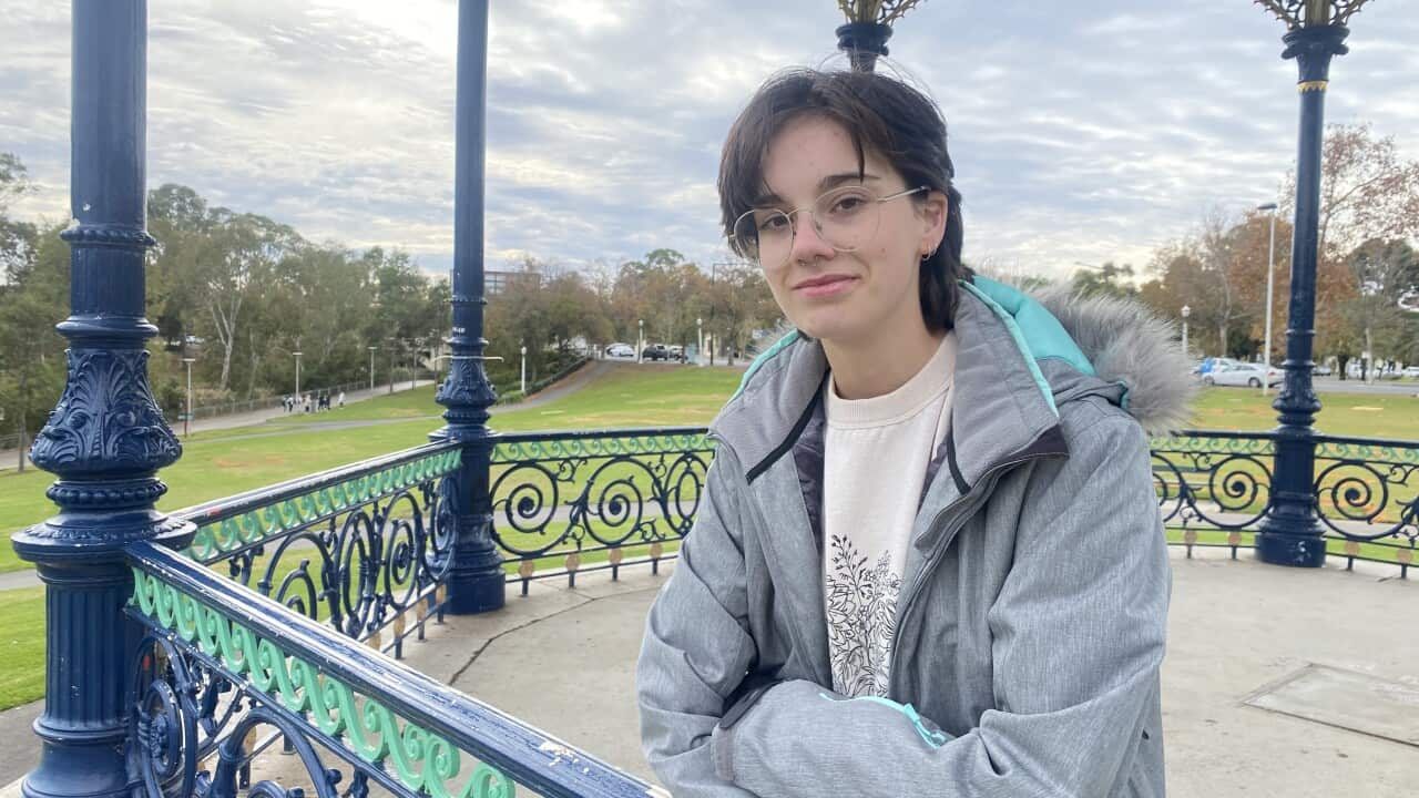 Một người mặc áo khoác phồng dựa vào hàng rào của vọng lâu.