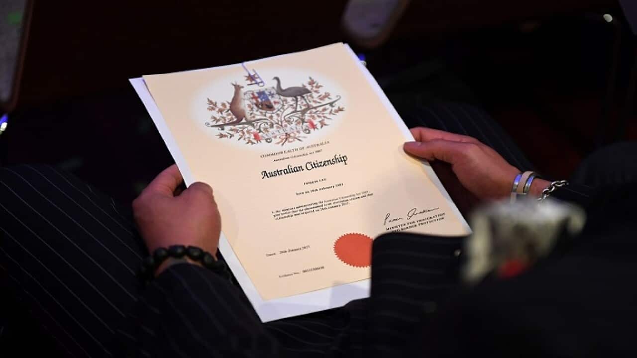 An Australian citizenship recipient holds his certificate during a citizenship ceremony on Australia Day in Brisbane, Thursday, Jan. 26, 2017. (AAP Image/Dan Peled) NO ARCHIVING