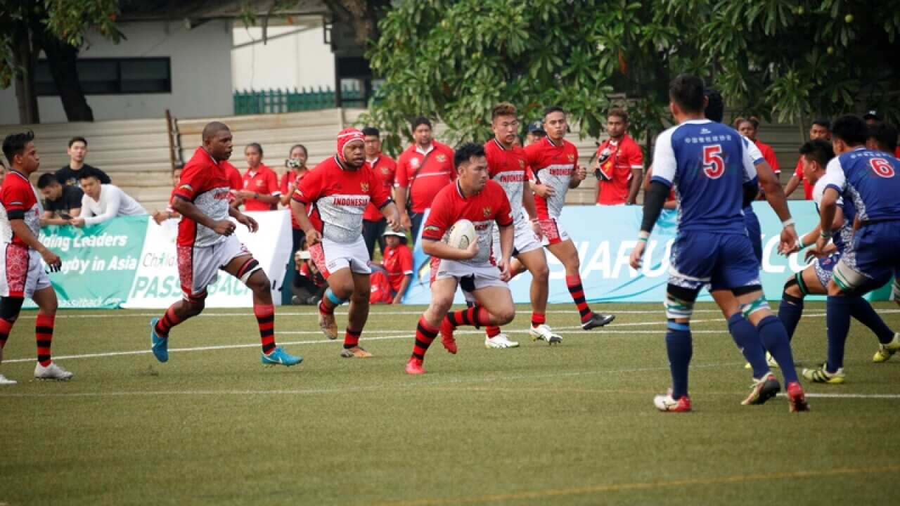 Daniel R Nugroho (holding the ball) leading his team in an Asia’s Rugby competition.