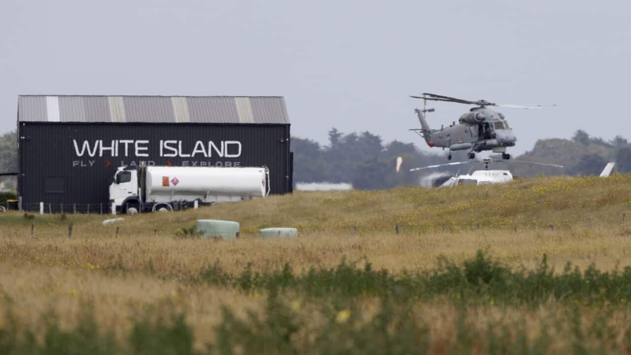 A Navy helicopter hovers at Whakatane Airport as the recovery operation to return the victims of the volcano eruption continues.
