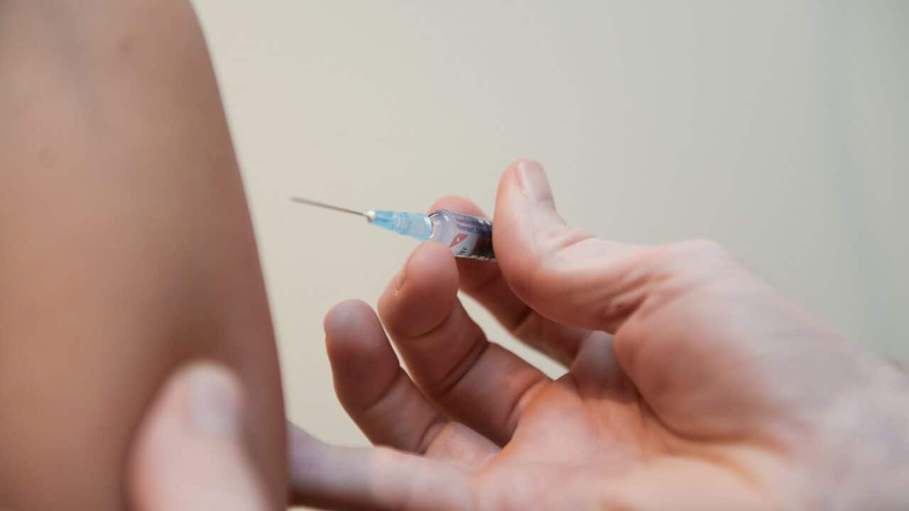 A doctor injects a vaccine at a clinic in Canberra.