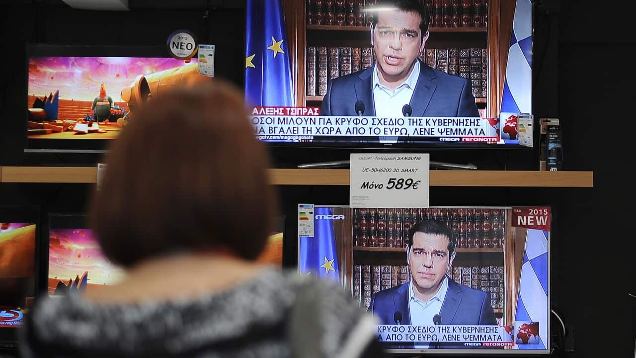 A woman watches Greece's Prime minister Alexis Tsipras' TV announcement in a electronics shop in central Athens, Greece, 01 July 2015. (EPA/FOTIS PLEGAS A.)