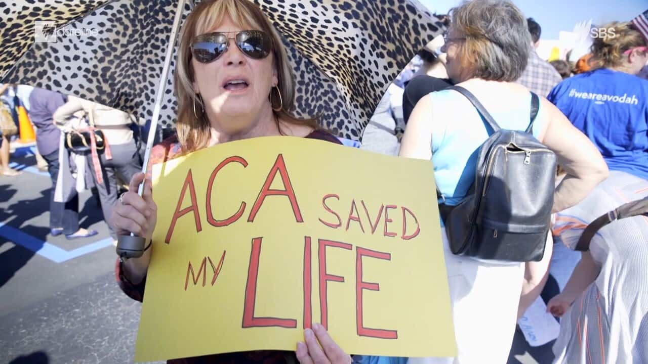 A woman holds an 'ACA Saved My Life' sign at a rally in New Orleans, Louisiana.