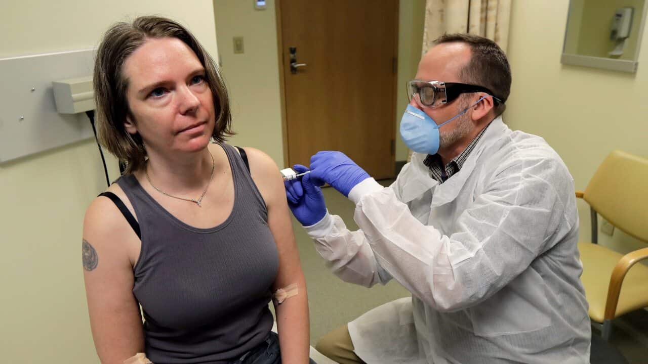 A woman in the US is given the first shot in the clinical trial of a potential vaccine for the COVID-19 coronavirus by a pharmacist.