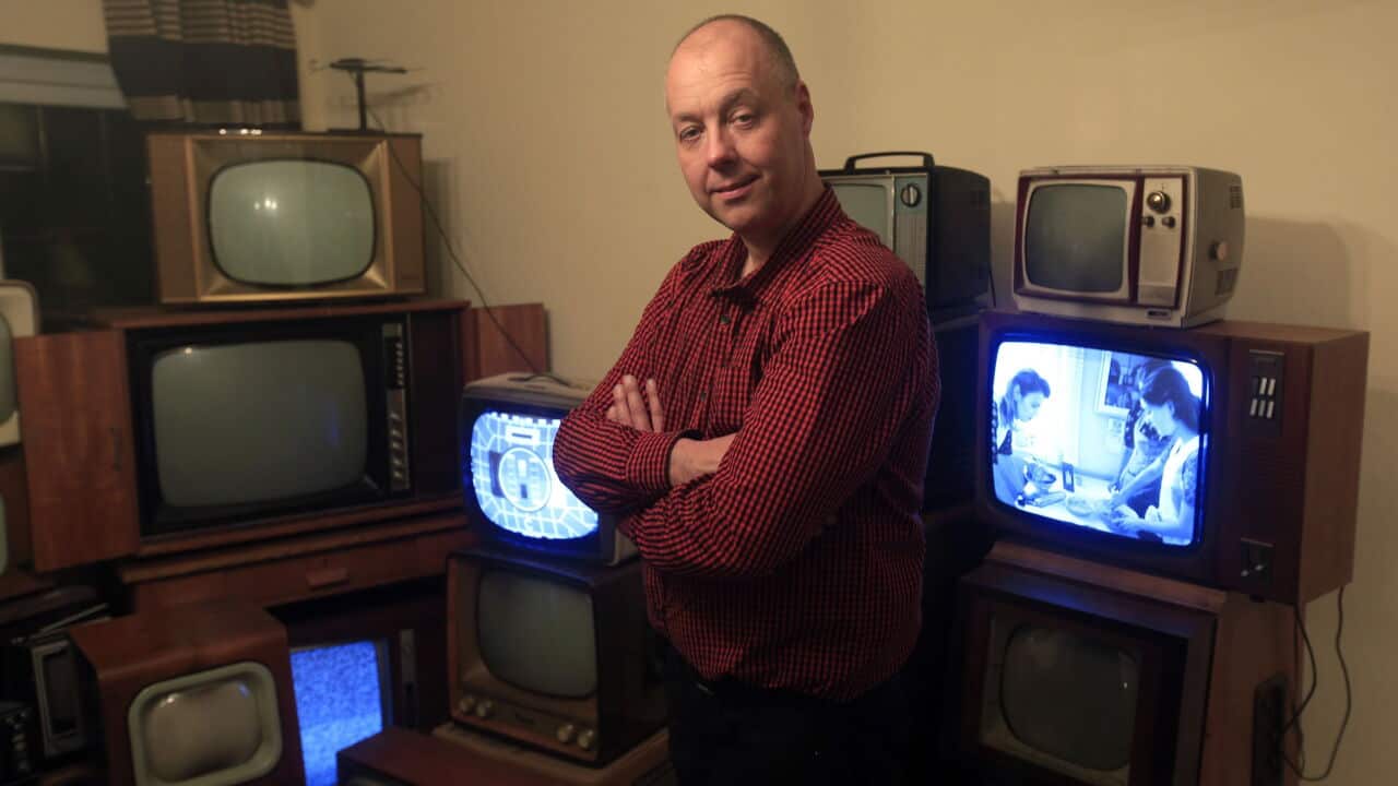 John Thompson stands amongst part of his collection of vintage black and white televisions at his home in Enfieldm, north London.