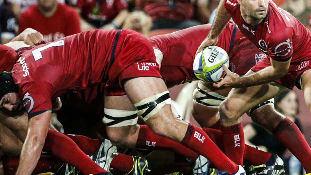 Queensland Reds player Nick Frisby passes from the scrum