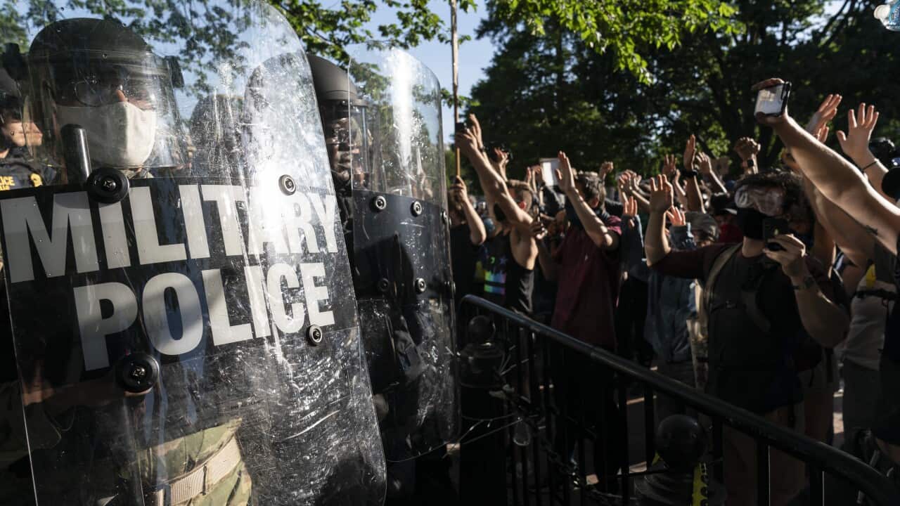 Protesters raise their hands to military police during a demonstration on 1 June, 2020 in Washington, DC.