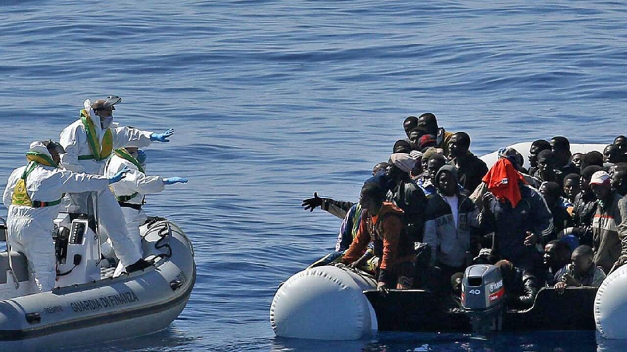 Migrants crowd an inflatable dinghy during a rescue mission