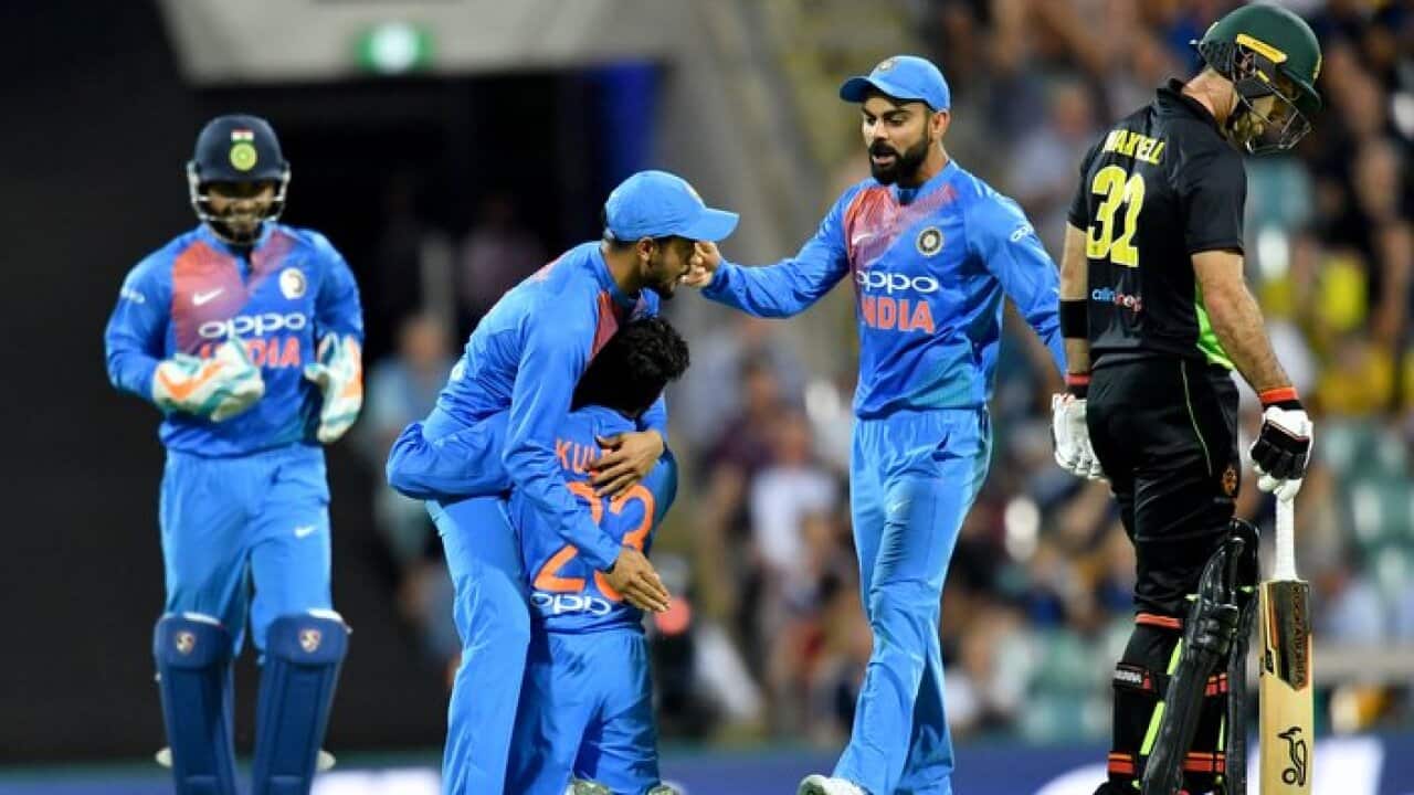 Kuldeep Yadav celebrates with team mate Manish Pandey and Virat Kohli after getting the wicket of Chris Lynn of Australia during the first T20 at The Gabba.