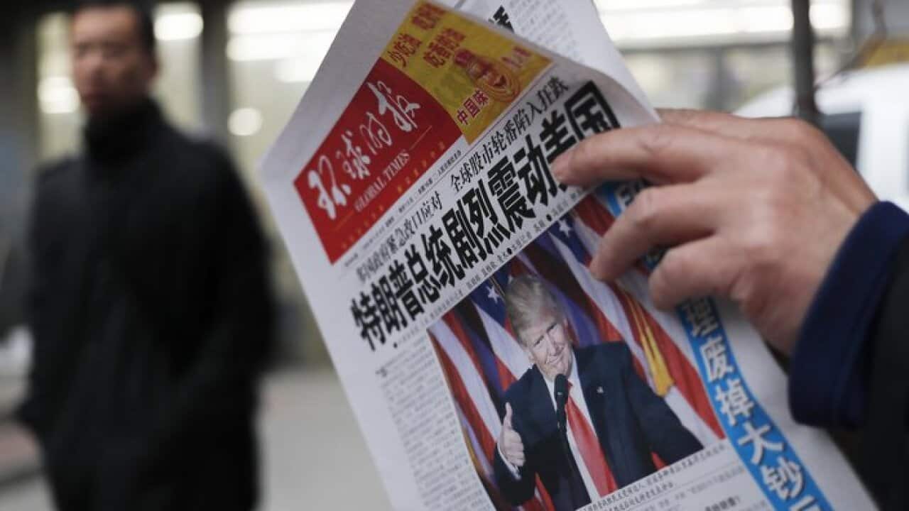 A man reads a newspaper. (AP Photo/Andy Wong, File)